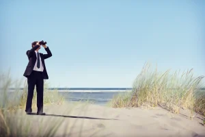 Business man looking through binoculars
